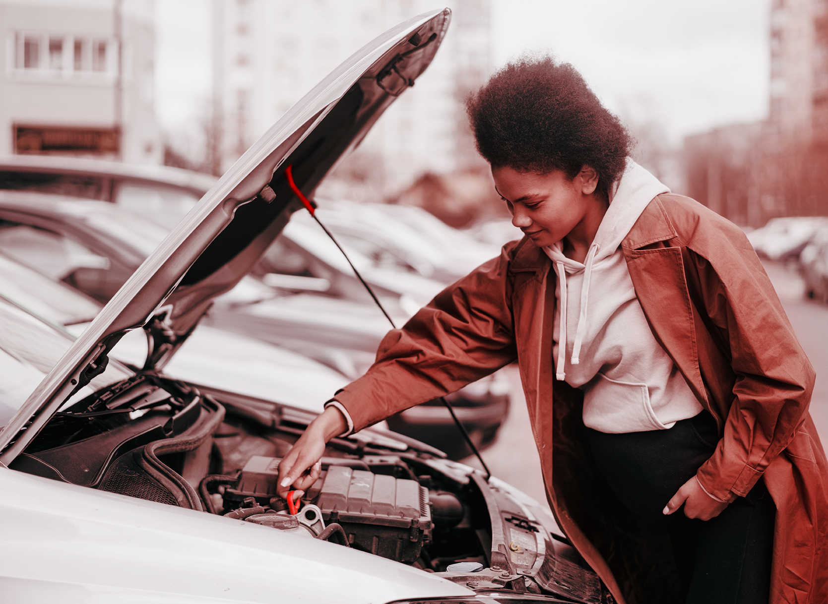 Mulher verificando o óleo do carro com o capô aberto.